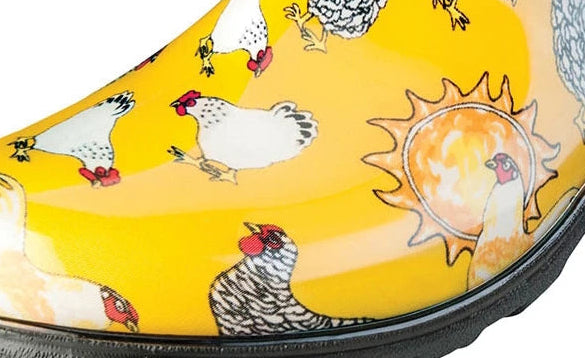 Yellow clog shoe with chicken pattern on a white background