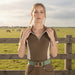 Woman wearing a brown and beige outfit with a belt against a gray background